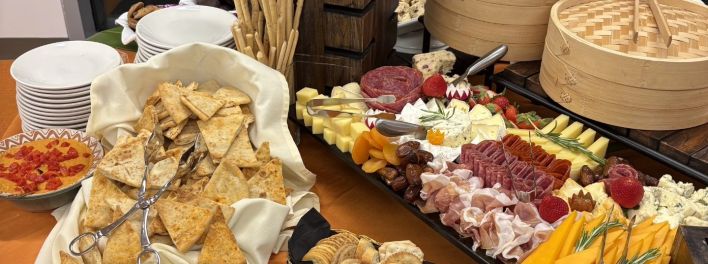 Vibrant close-up of a cheese and charcuterie platter with assorted fruits and salami.